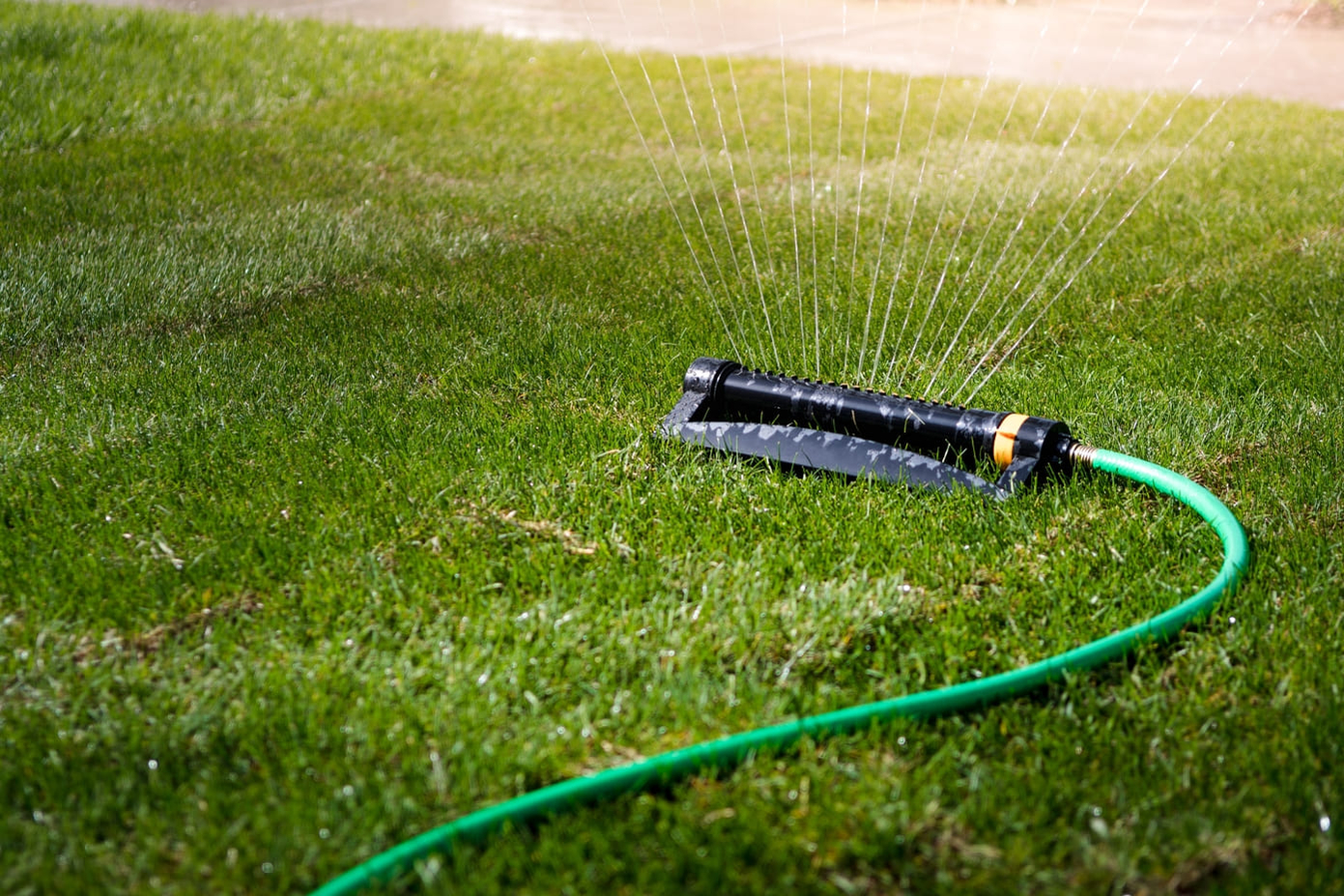 water-sprinkler-spraying-water-on-green-grass-lawn water-sprinkler-spraying-water-on-green-grass-lawn
